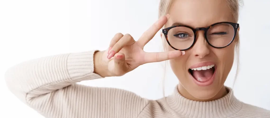 hey-smile-you-portrait-cheeky-cute-glamour-blond-woman-glasses-combed-hair-sweater-winking-happily-showing-peace-victory-gesture-as-fooling-around-being-optimistic